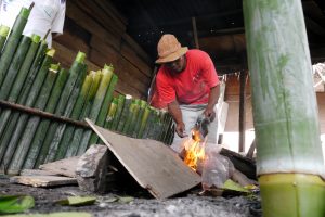 Warga membakar kayu untuk memasak lemang bambu di Desa Lamdingin, Syiah Kuala, Banda Aceh, Aceh, Rabu (10/7)
