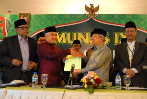 Ketua Majelis Ulama Indonesia (MUI) terpilih, Ma'ruf Amin (kedua kanan) menerima hasil rapat tim formatur dari ketua MUI yang lama Din Syamsuddin (kiri) disela-sela penutupan Musyawarah Nasional (Munas) IX MUI di Surabaya, Jawa Timur, Kamis (27/8) dini hari. Ma'ruf Amin terpilih menjadi ketua MUI periode 2015-2020 secara musyawarah mufakat melalui tim formatur. ANTARA FOTO/M Risyal Hidayat/foc/15.