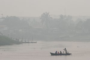 Sebuah perahu melintas di Sungai Siak yang dipenuhi kabut asap di Pekanbaru, Riau, Selasa (1/9). Sebagian wilayah di Riau masih diselimuti kabut asap pekat dampak kebakaran hutan dan lahan sementara pemda setempat menghimbau  seluruh masyarakat untuk menggunakan masker pelindung pernapasan bila beraktivitas di luar ruangan. ANTARA FOTO/Rony Muharrman/nz/15