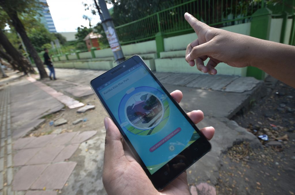 Penggemar game berburu pokemon di layar androidnya, di Makassar, Sulawesi Selatan, Jumat (15/7). Meski belum resmi diluncurkan di Indonesia, permainan Pokemon Go berbasis realitas (augmented reality AR) sudah diminati banyak kalangan. ANTARA FOTO/Dewi Fajriani/ama/16