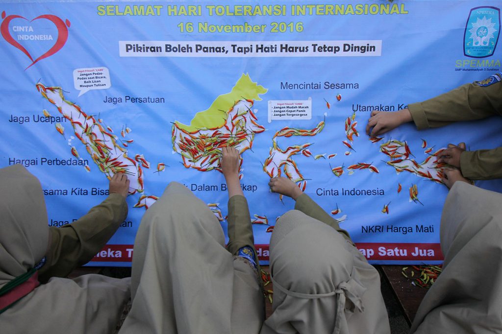 Pelajar SMP Muhammadiyah 5 Surabaya bersama-sama menempelkan cabai pada peta Indonesia di Surabaya, Jawa Timur, Rabu (16/11). Aksi sebagai bentuk ajakan kepada masyarakat untuk tidak mudah terprovokasi oleh hasutan yang dapat memecah belah bangsa tersebut dalam rangka memperingati Hari Toleransi Internasional. ANTARA FOTO/Didik Suhartono/ama/16